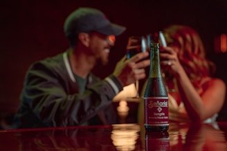 a man and a woman sitting at a table with a bottle of wine
