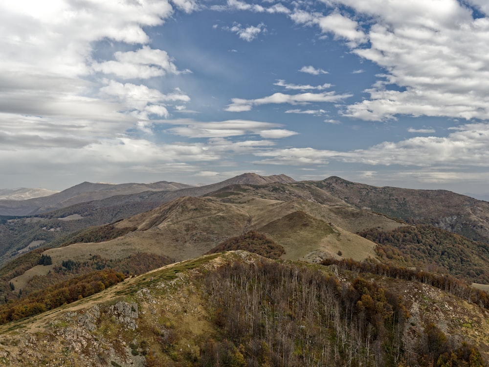 a view of a mountain range with a few clouds in the sky