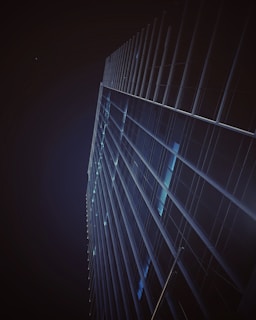 A nighttime shot of a completed commercial building illuminated, emphasizing its steel and glass structure.