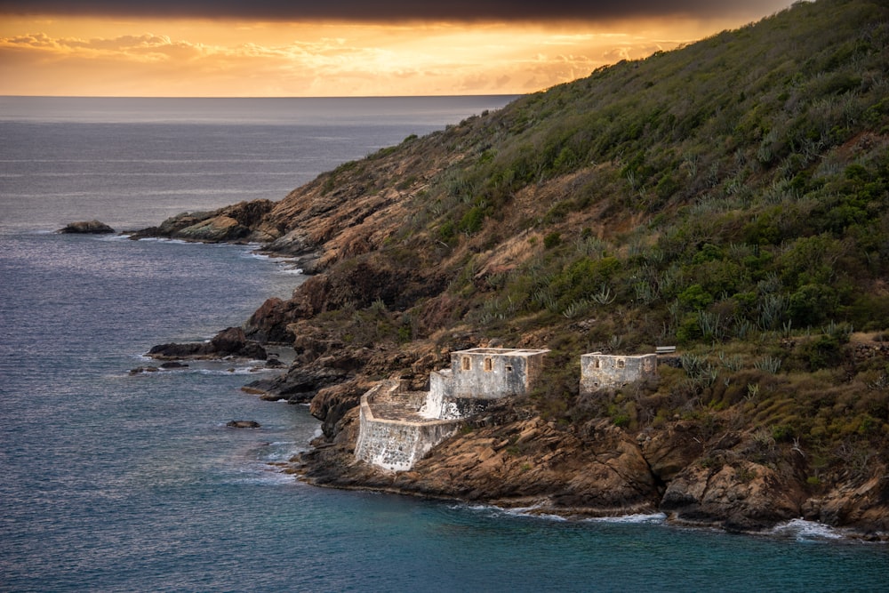 a rocky cliff with a body of water below it