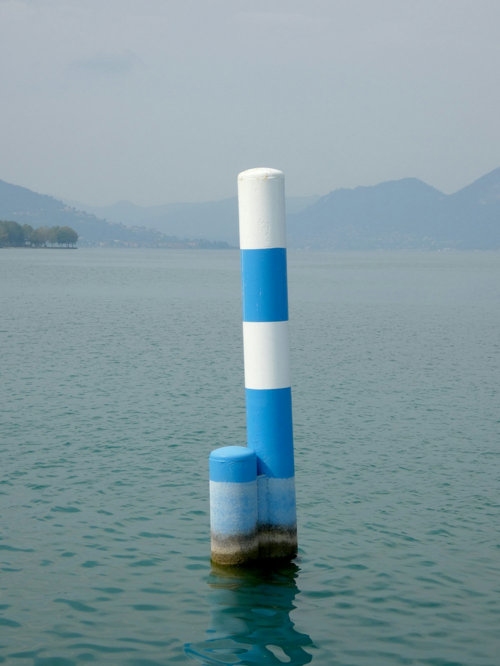 eine blau-weiße Stange, die aus dem Wasser ragt