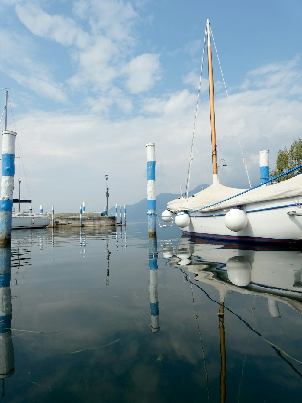 a sailboat sitting in the water next to a dock