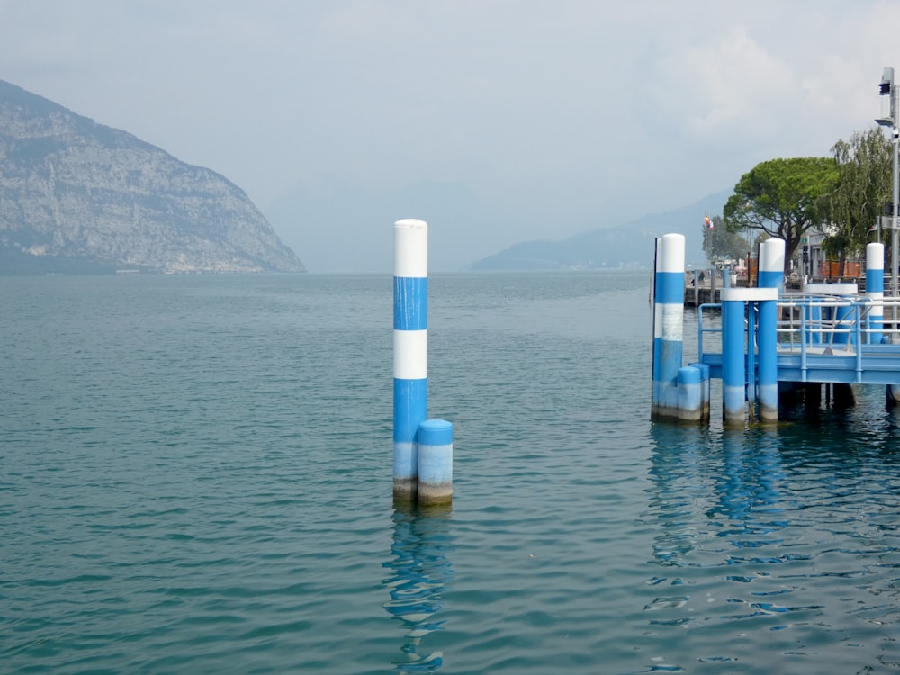 a body of water with blue and white poles sticking out of it