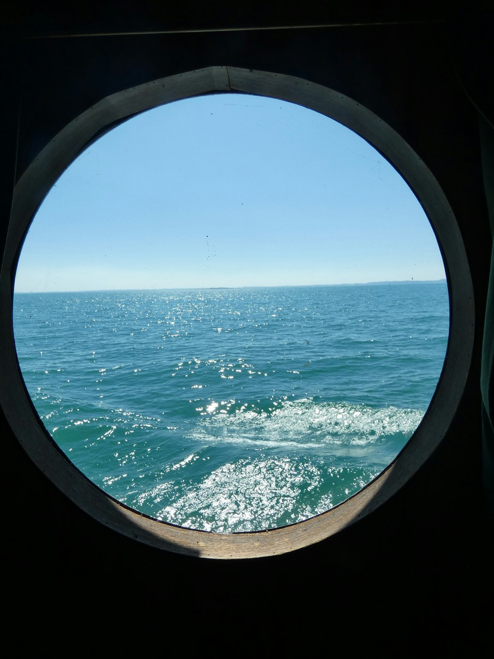 Una vista del océano a través de una ventana de ojo de buey