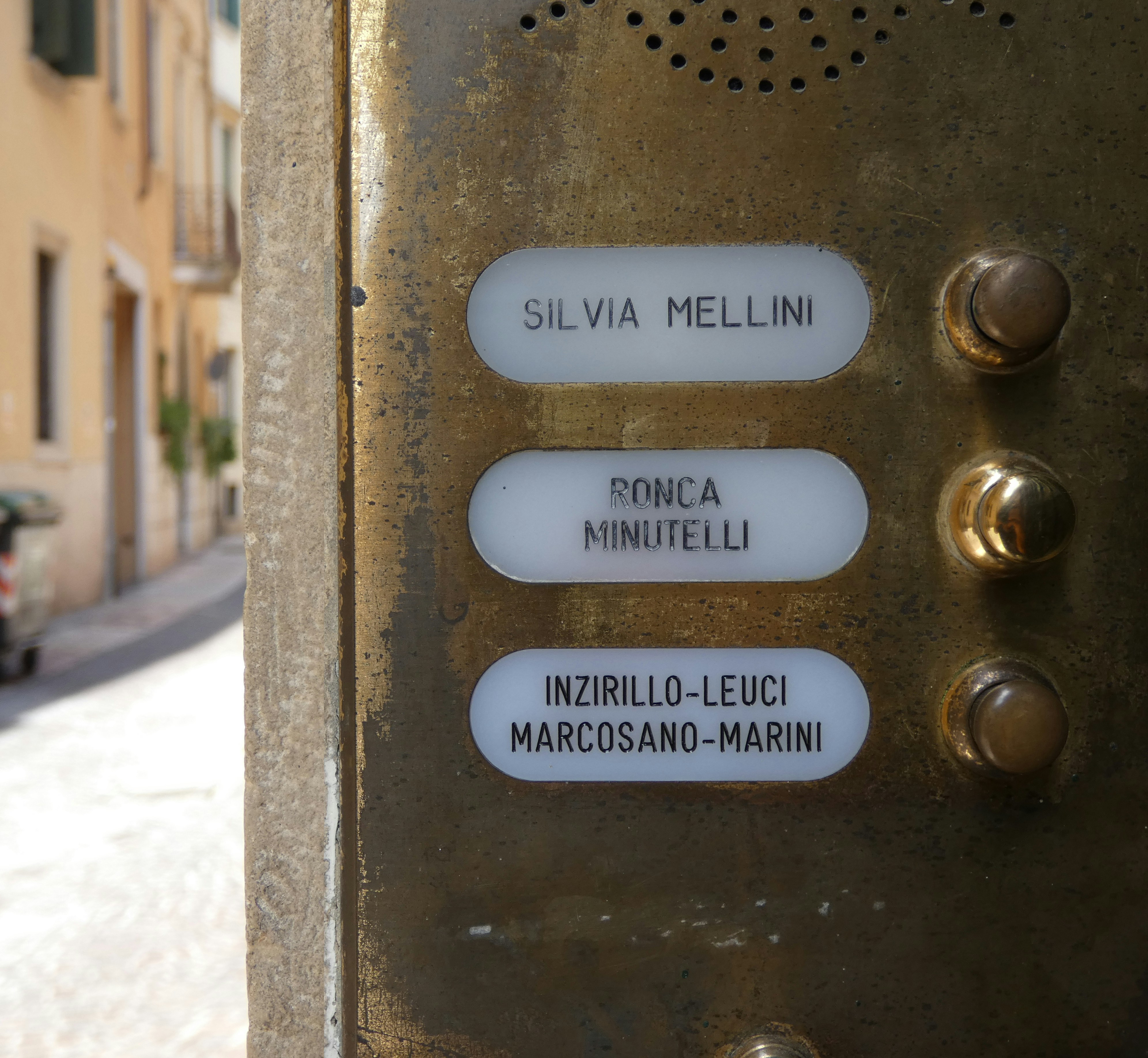 Un primo piano di un cartello stradale con un edificio sullo sfondo
