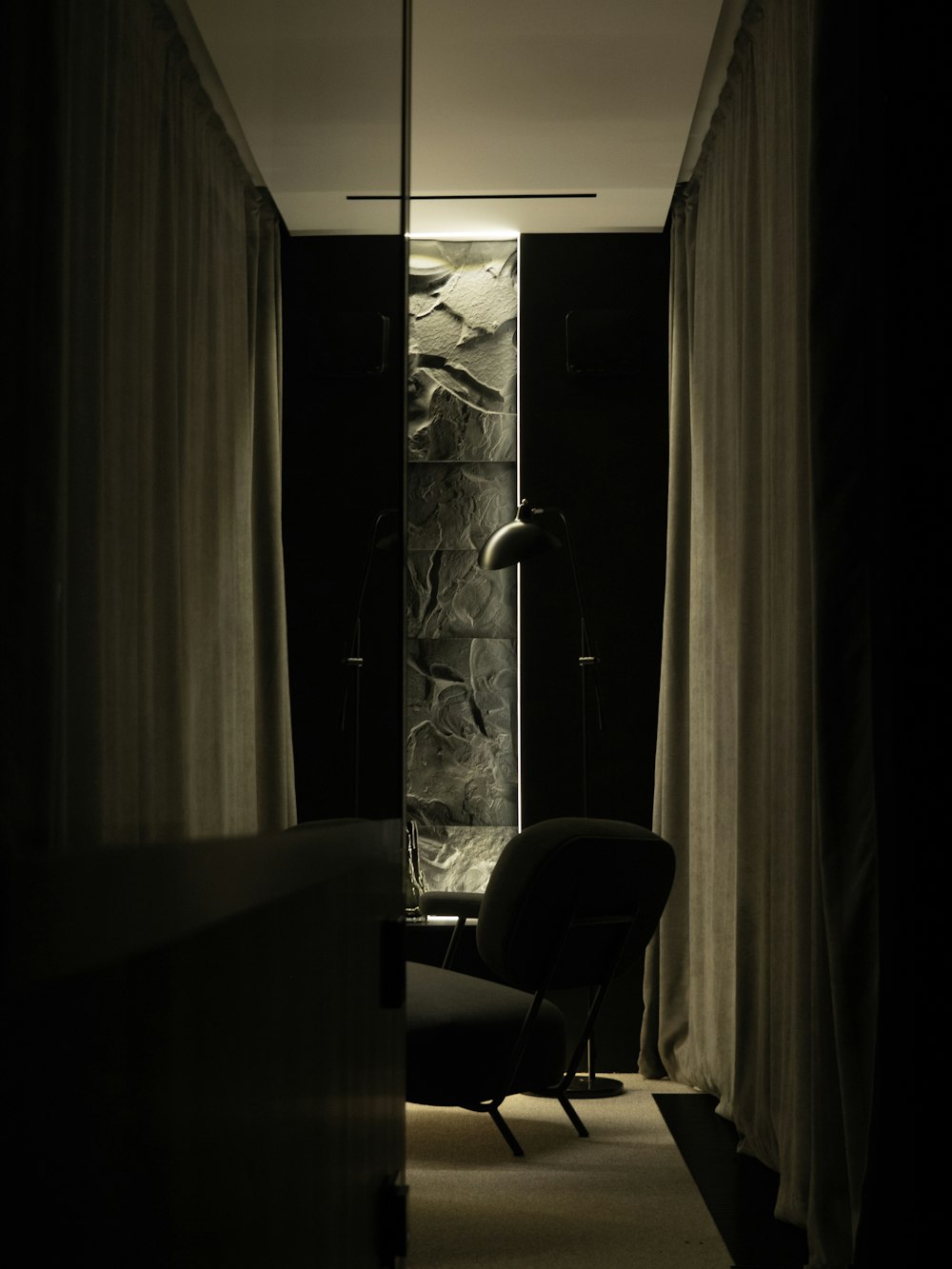 Una foto en blanco y negro de una silla en una habitación oscura