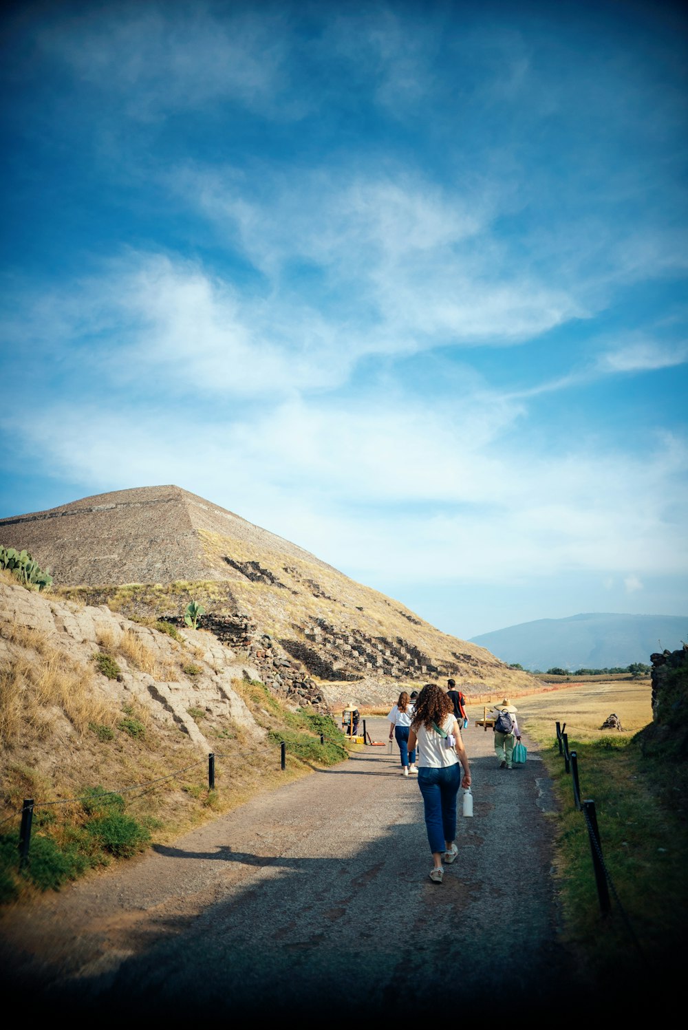 a group of people walking down a dirt road