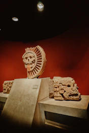 Ancient stone carvings glowing softly in ambient low light, revealing symbols of Mexican heritage.