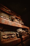 a close up of a wooden shelf with carvings on it