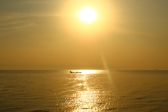 An artistic image of a serene boat floating on calm waters at sunset.