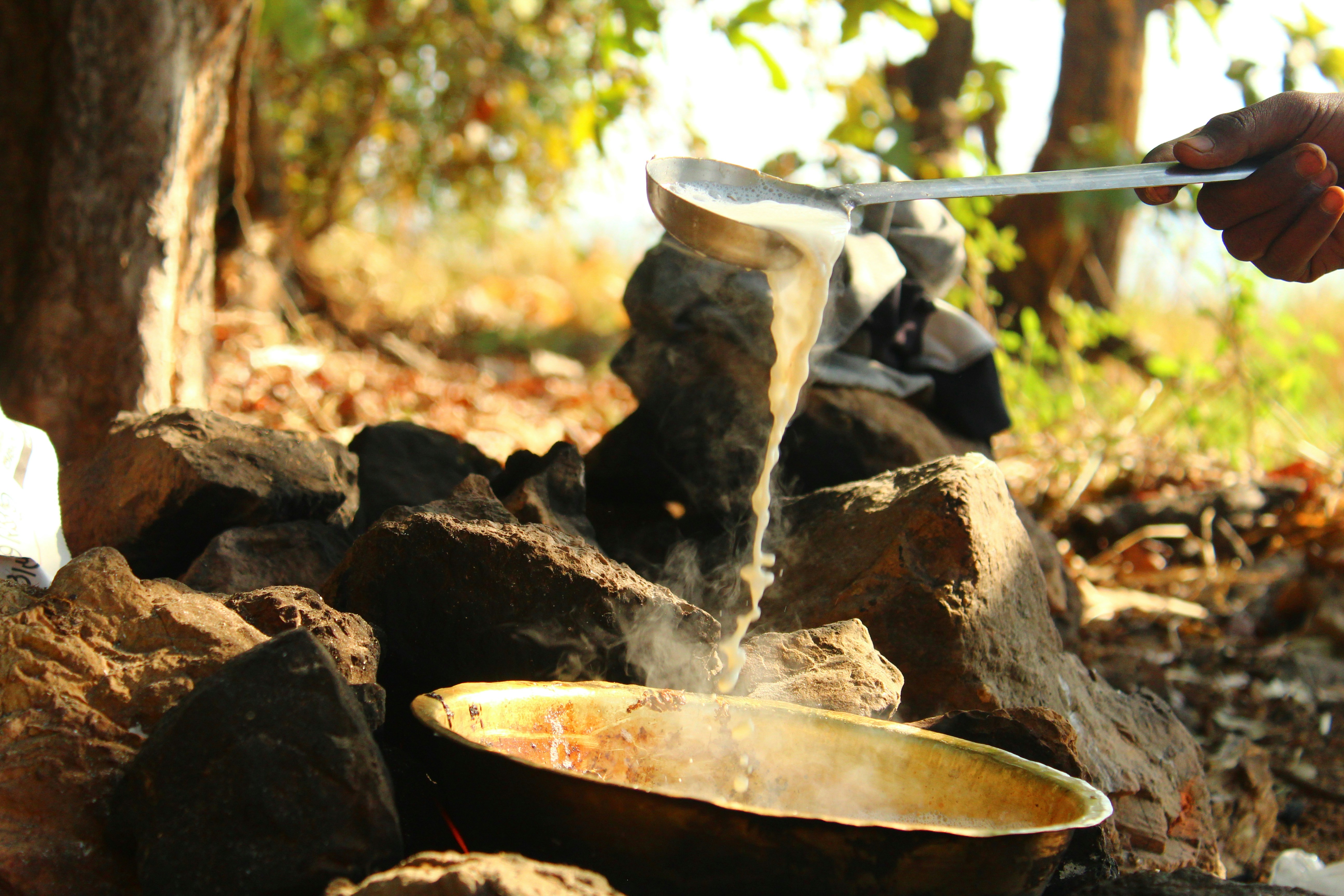 a person holding a knife over a bowl of food