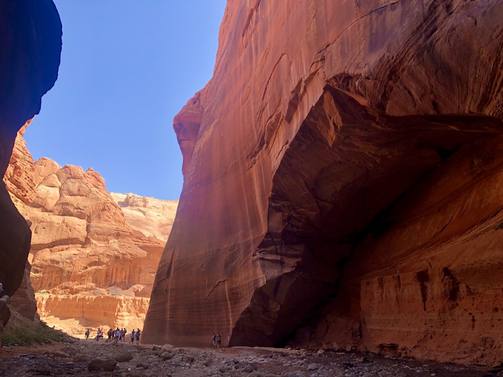 a group of people walking through a narrow canyon