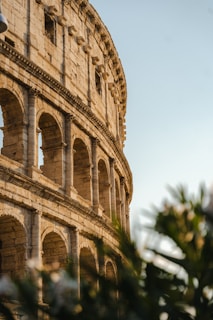 A solo traveler capturing a photo of an ancient historic site bathed in golden light.