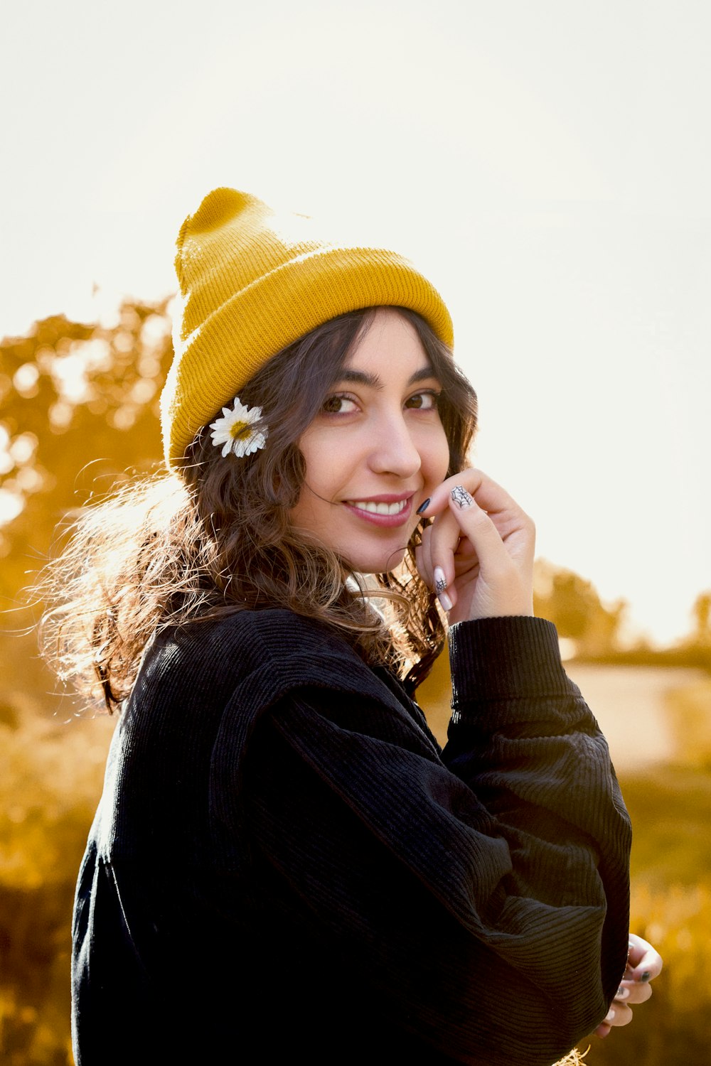 a woman in a yellow hat talking on a cell phone