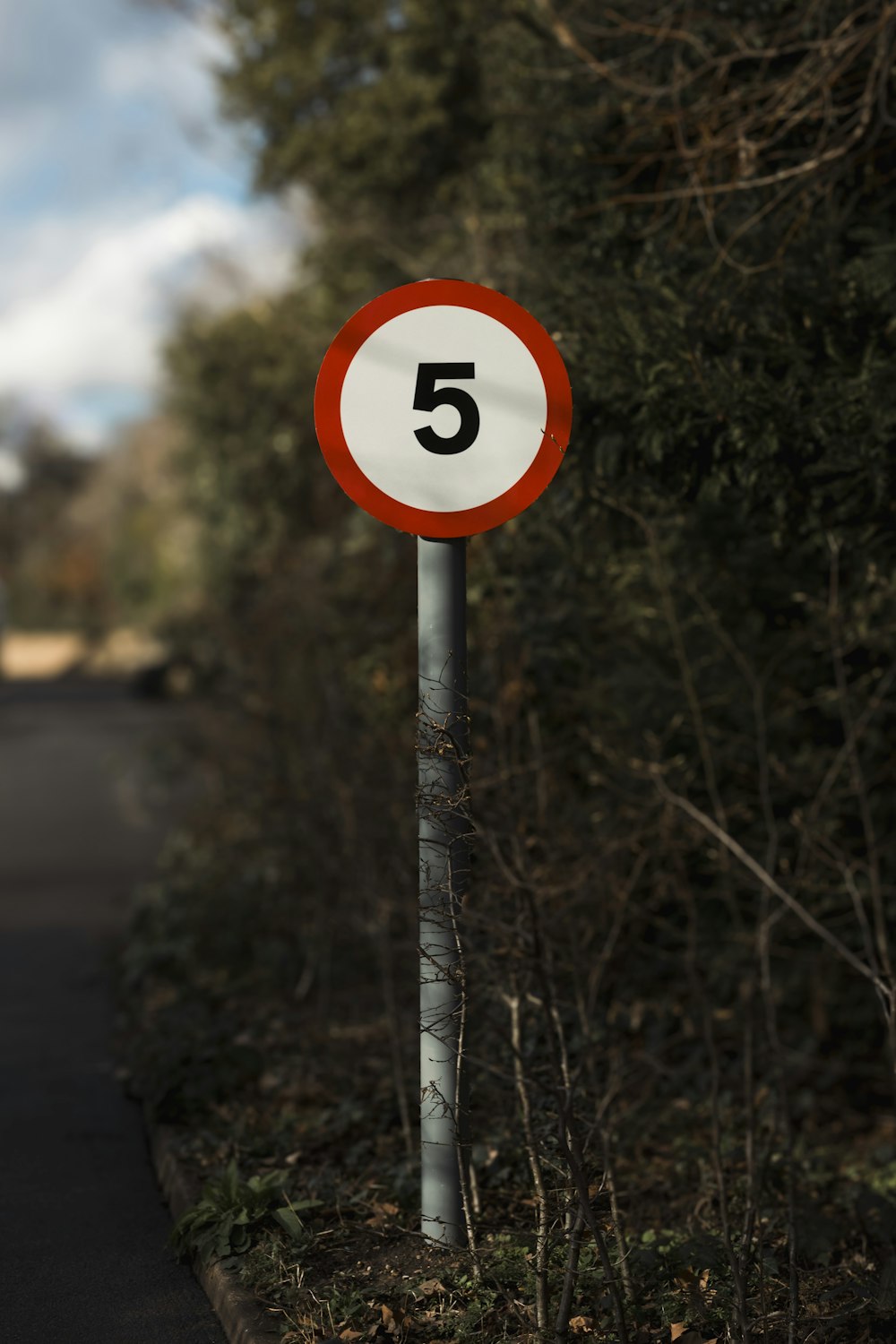 a red and white sign sitting on the side of a road