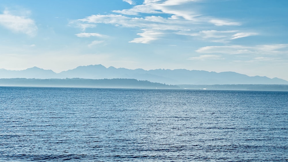 a large body of water with mountains in the background