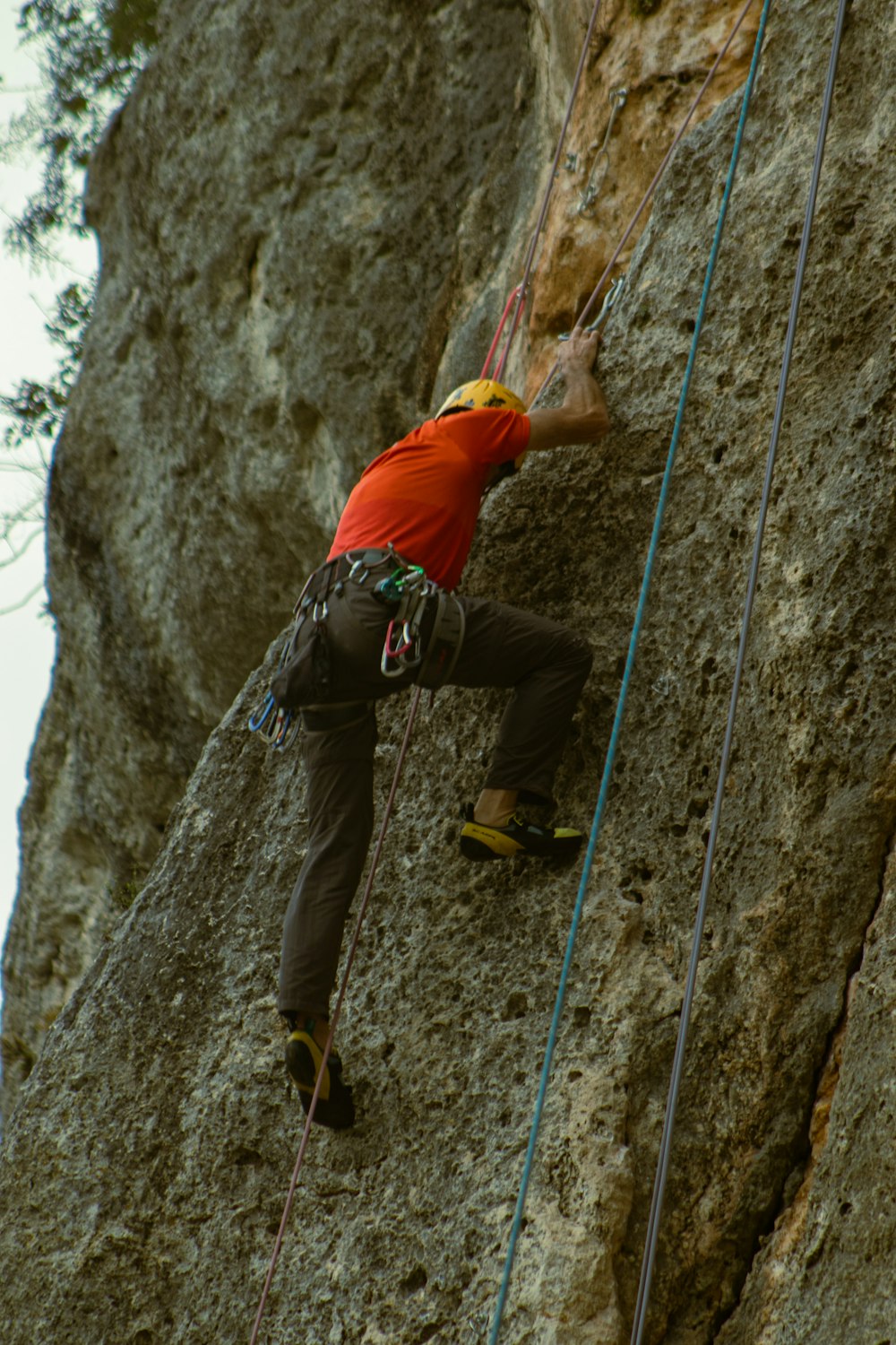 a man climbing up the side of a mountain