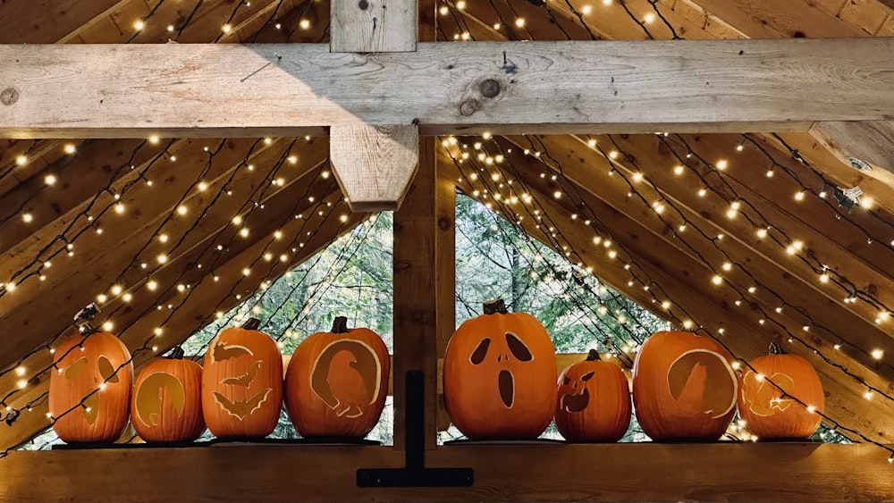 a group of pumpkins sitting on top of a wooden shelf