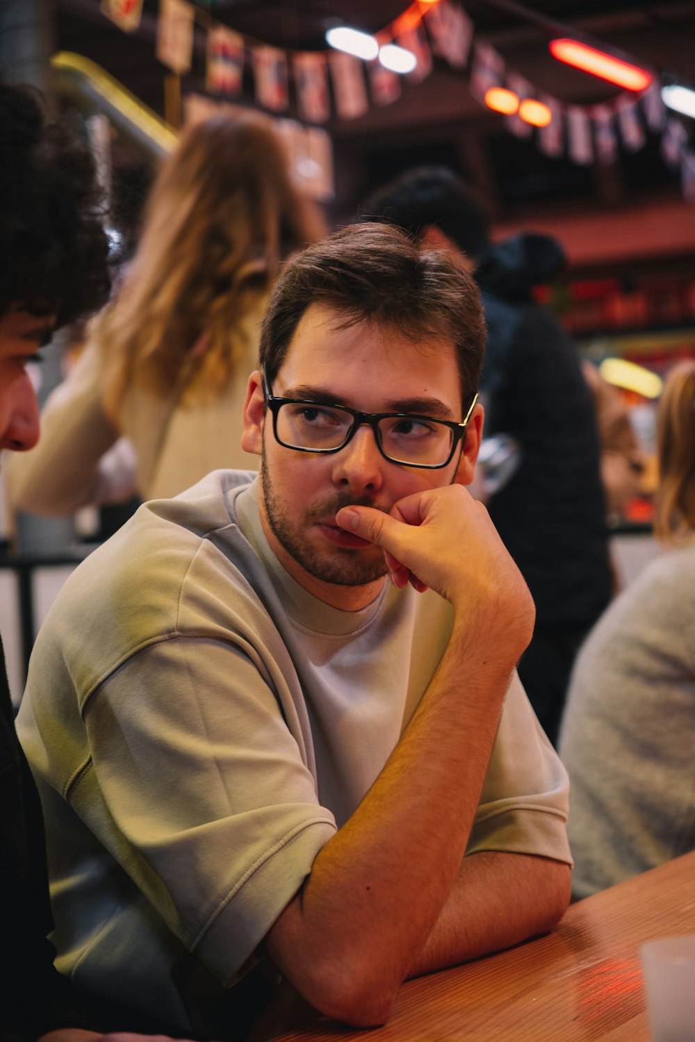 a man sitting at a table with his hand on his chin