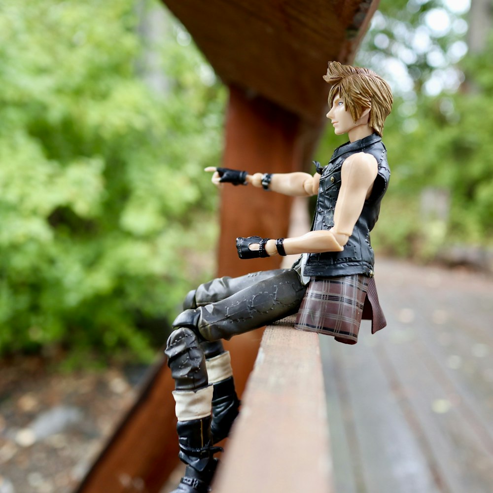 a toy figure sitting on top of a wooden bench