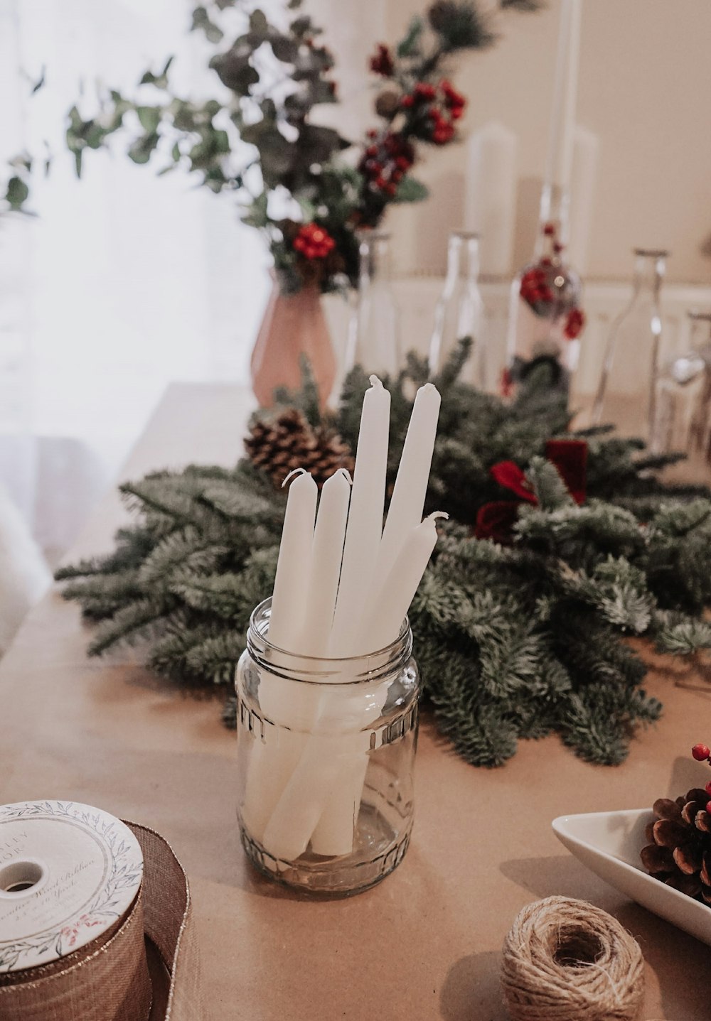 a table topped with a jar filled with white paper