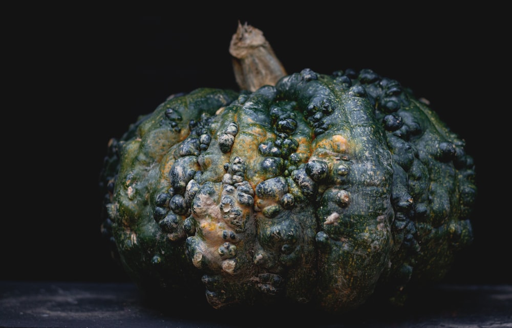 a close up of a green pumpkin on a table