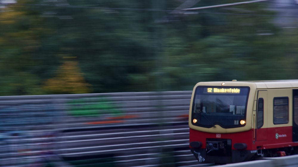 a red and yellow train traveling down train tracks