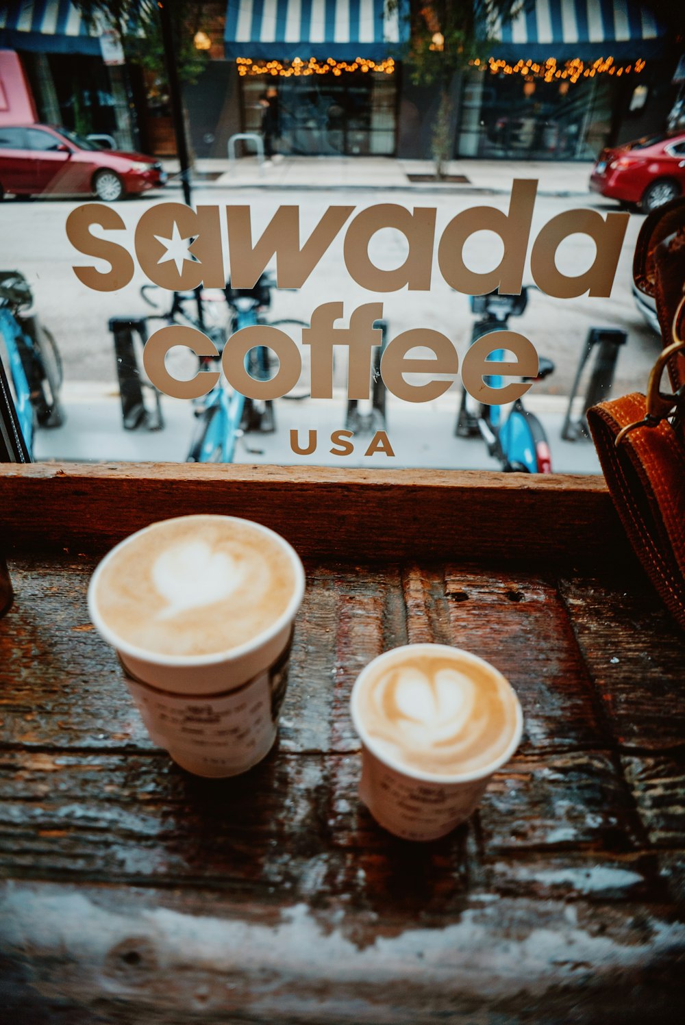 two cups of coffee sitting on a wooden table