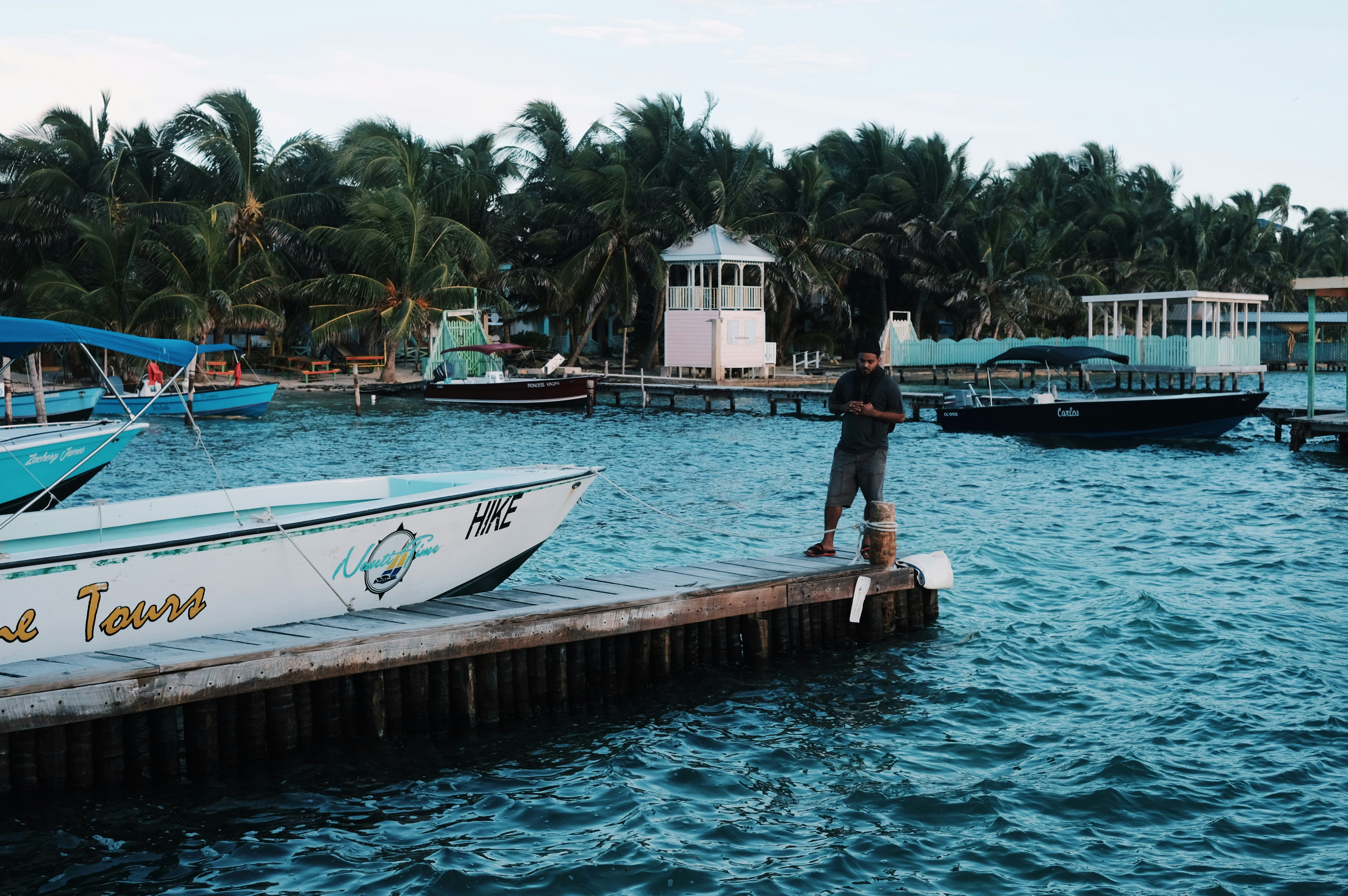 a man standing on a dock next to a boat