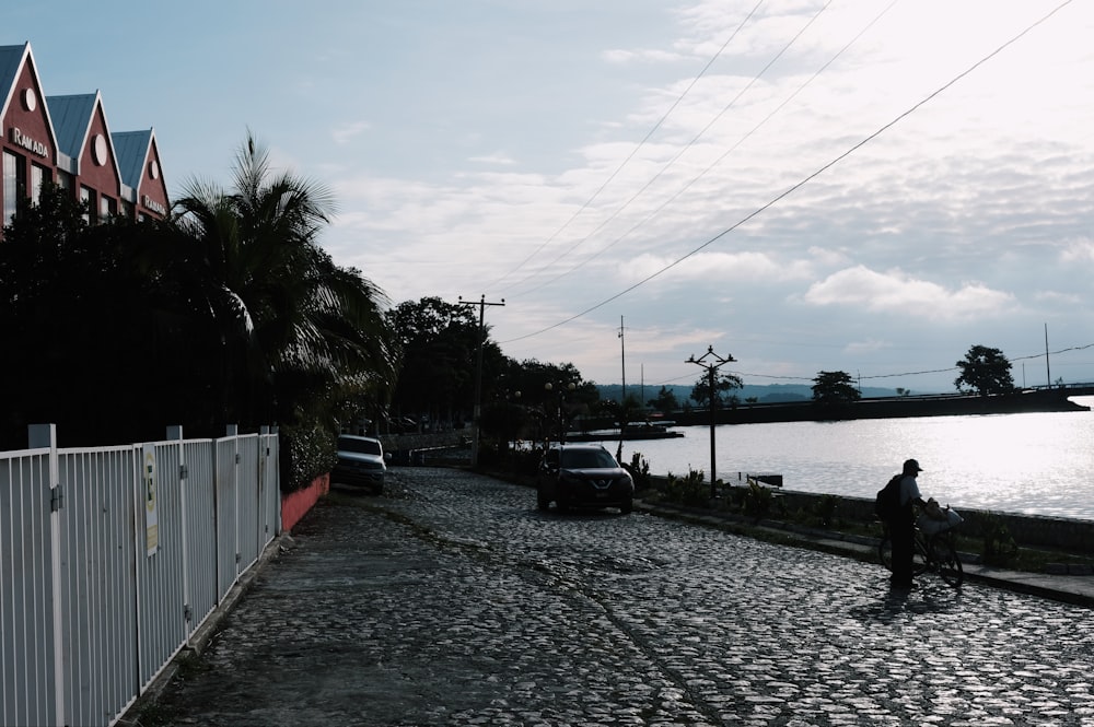 a man riding a bike down a cobblestone road