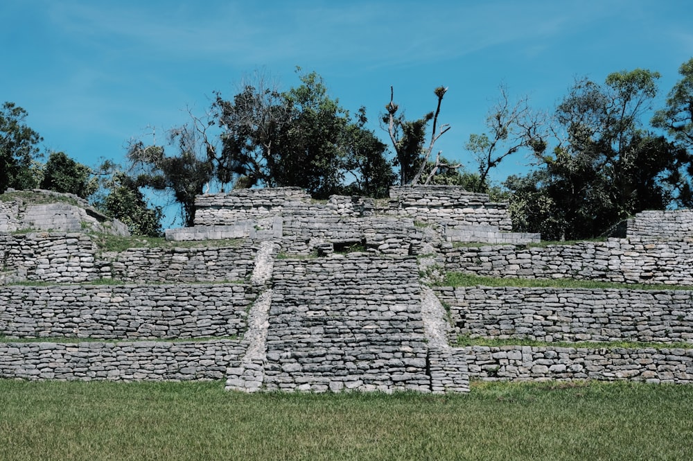 a stone structure with trees in the background