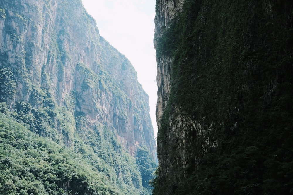 a boat floating on top of a river surrounded by mountains