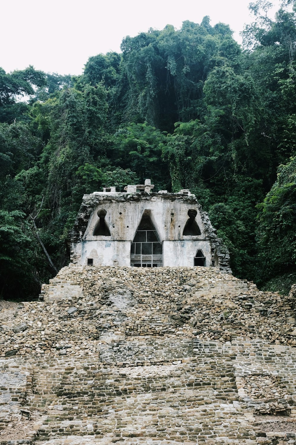 a stone structure in the middle of a forest