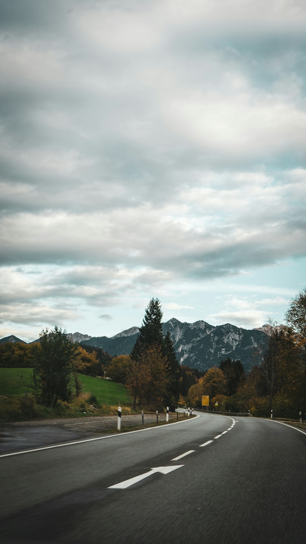 an empty road with mountains in the background