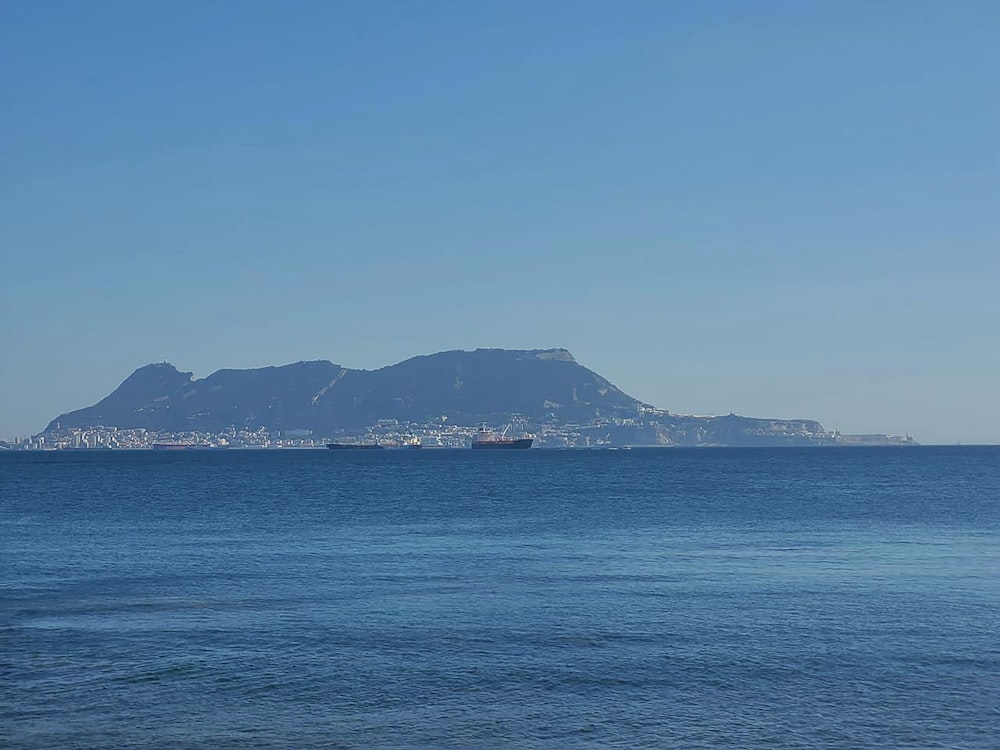 a large body of water with a mountain in the background