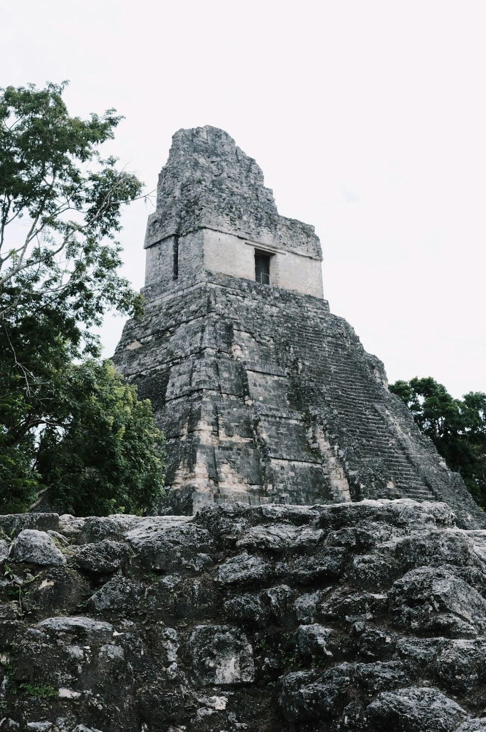 a large stone structure with trees in the background