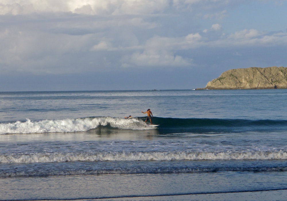 a man riding a wave on top of a surfboard