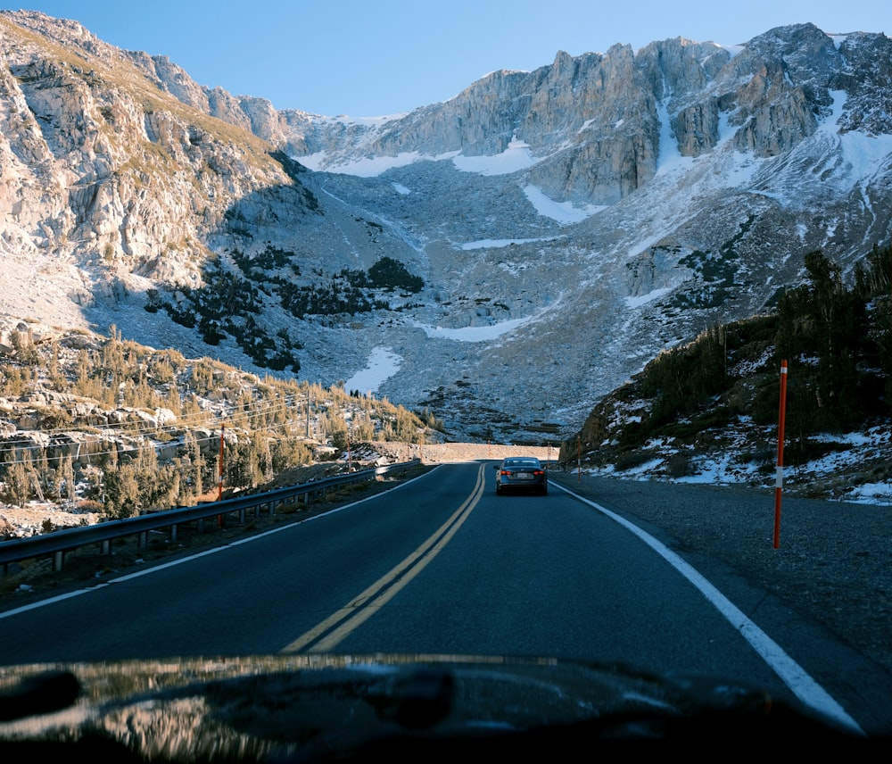 a car driving down a road in the mountains