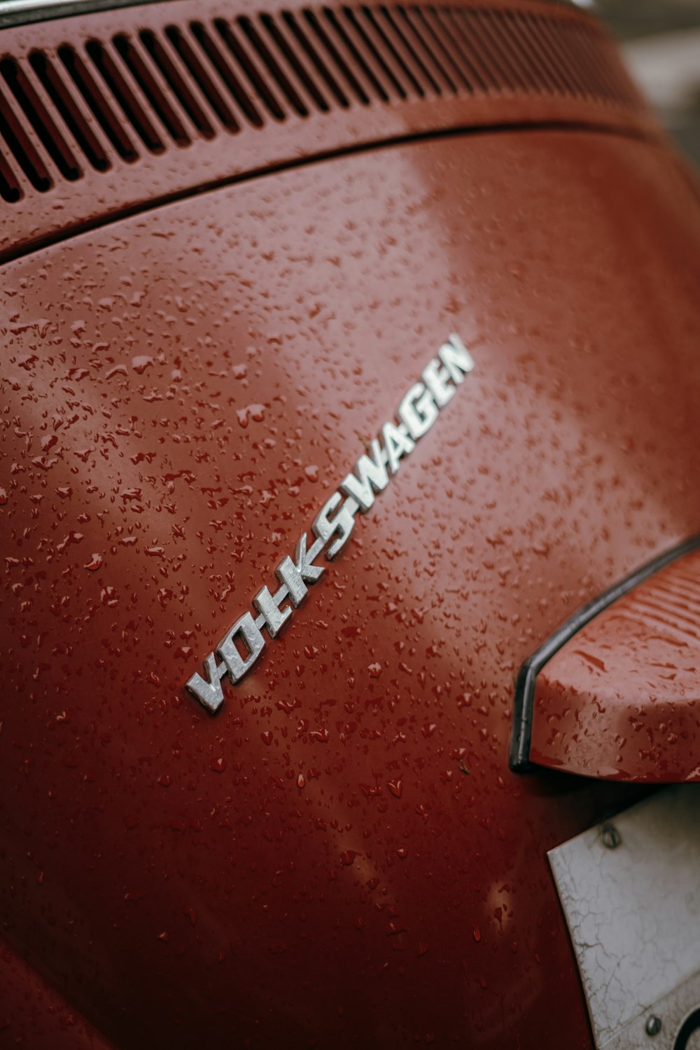 Um close up da palavra Volkswagen em um carro vermelho