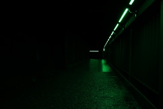 A covert rescue team navigating a dark, debris-filled space corridor illuminated by faint green digital glows.