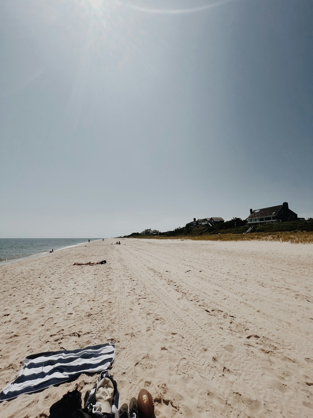 a blanket and a pair of shoes on a beach