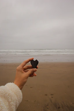 A gentle hand holding a smooth stone symbolizing calm and connection.