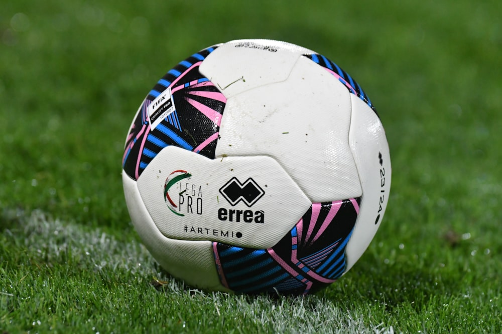 a soccer ball sitting on top of a lush green field