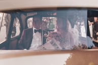 A couple stepping out of a classic car on their wedding day.