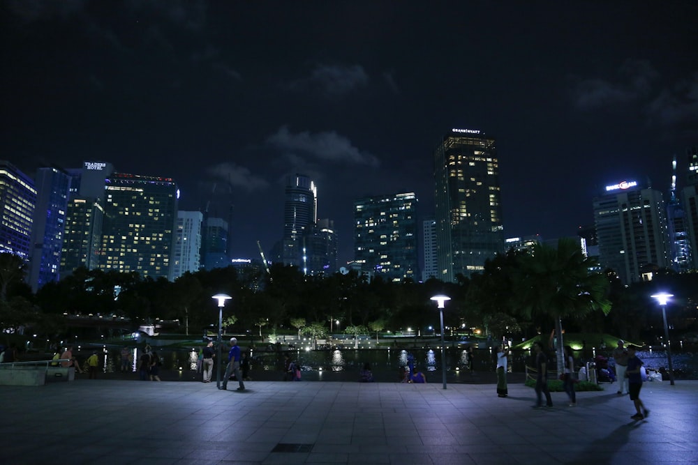 a city skyline at night with people walking around