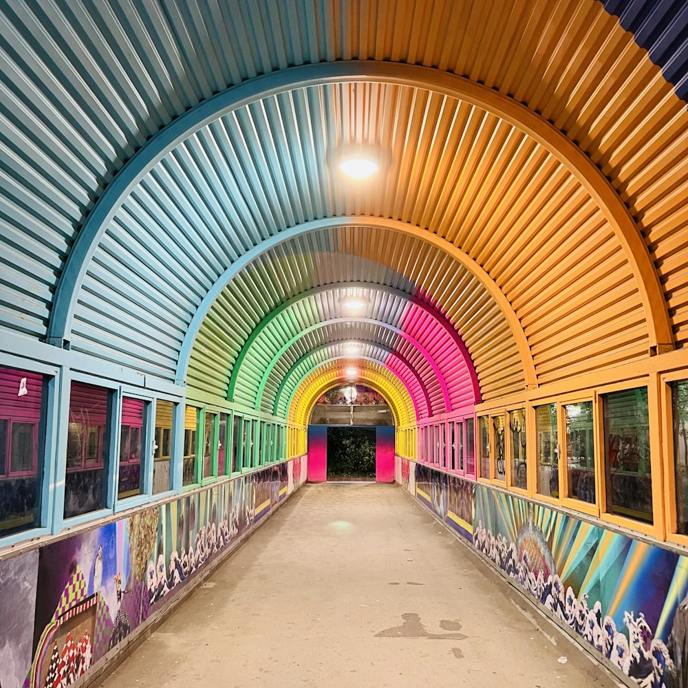 a long tunnel with colorful walls and graffiti on the walls