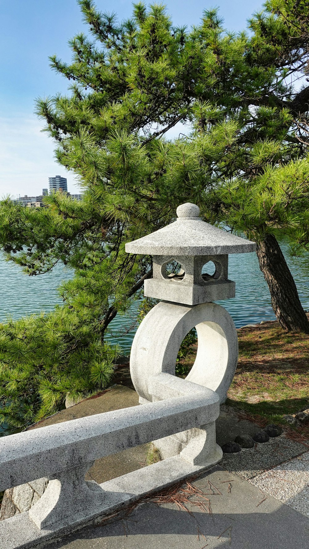 a stone lantern sitting on top of a cement bench