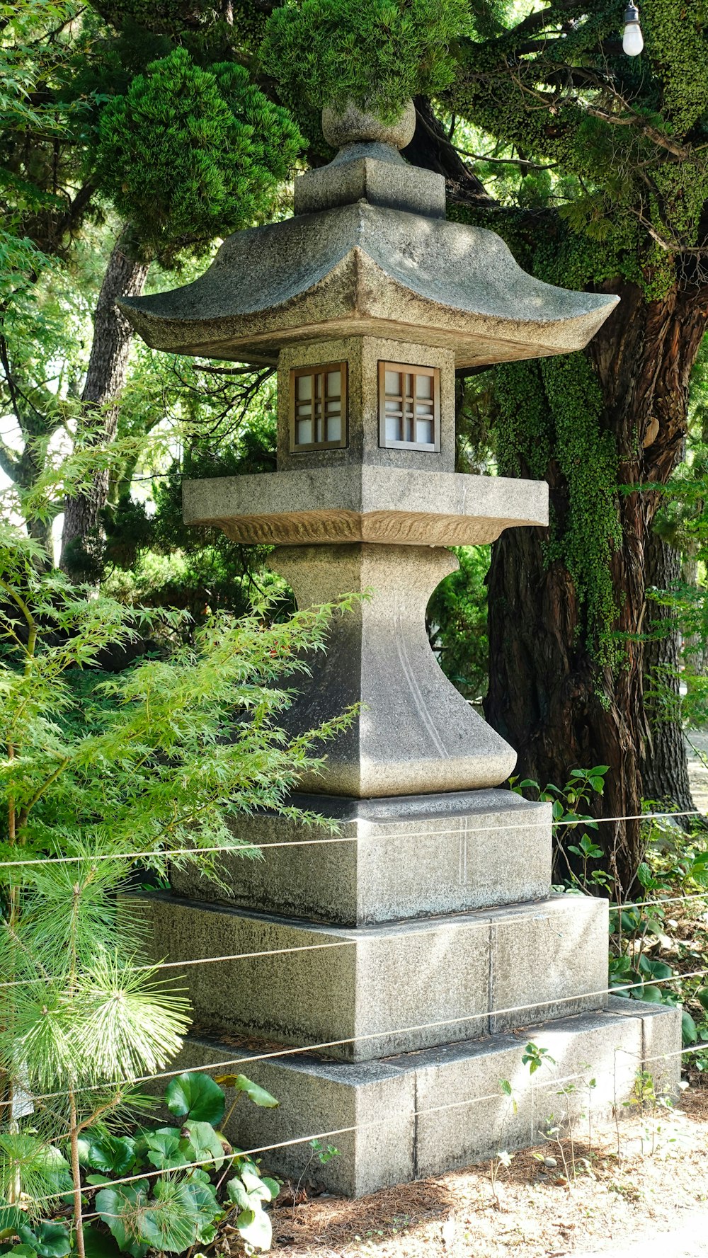 a stone lantern in the middle of a garden