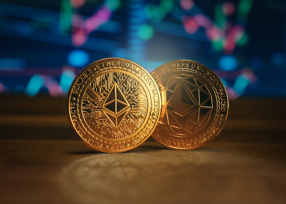 two gold coin sitting on top of a wooden table