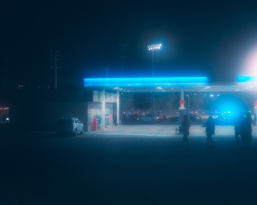 um casal de pessoas em frente a um posto de gasolina